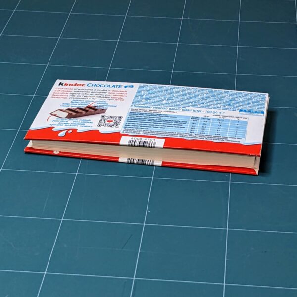 Handmade notebook with upcycled cover of Kinder chocolate package binded by an artist Žilvinas Bražukas Production. Rankų darbo užrašinė su pernaudota Kinder Šokolado pakuote